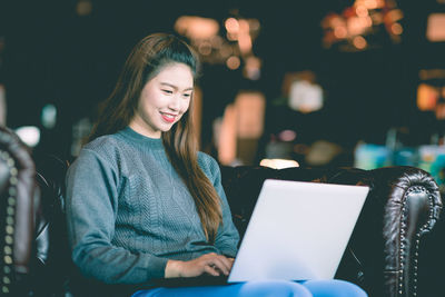 Portrait of smiling young woman using mobile phone