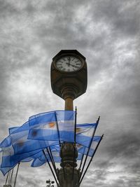 Low angle view of clock tower against cloudy sky