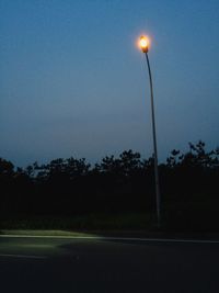 Illuminated road against sky at night