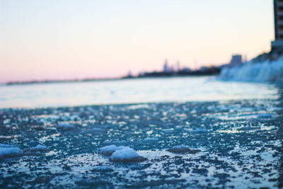 Surface level of frozen sea against sky during sunset