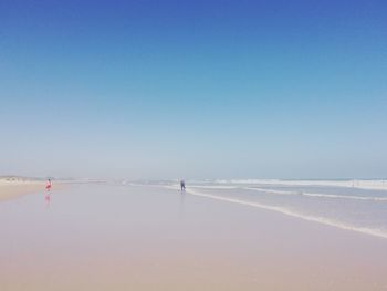 Scenic view of beach against clear blue sky