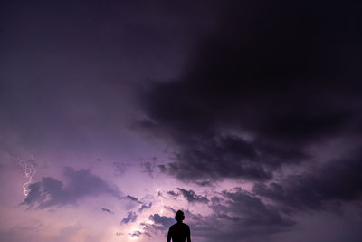 Low angle view of silhouette man against purple sky