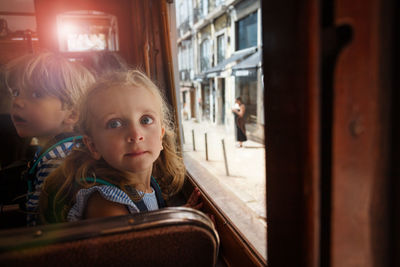 Portrait of cute girl sitting in train