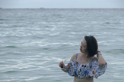 Woman standing against sea