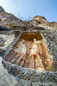 Low angle view of rock formation against sky