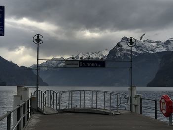 View of sign by sea against sky