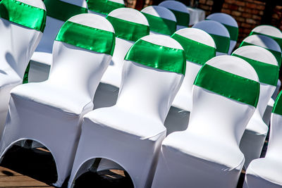 Green tied bow on chairs arranging at wedding