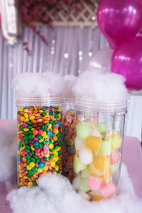 Close-up of multi colored candies in glass jar on table