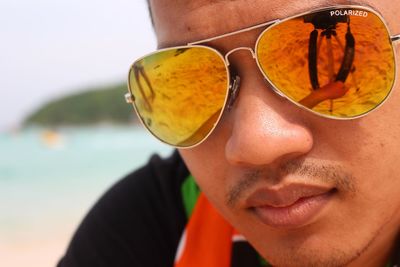 Close-up portrait of young man wearing sunglasses