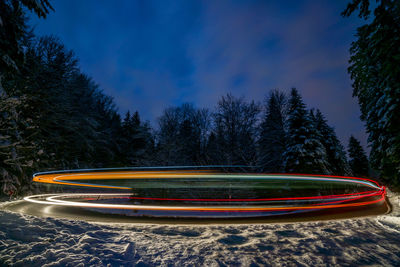 Light trails against blue sky at night