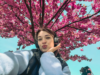 Portrait of smiling young woman sitting on tree