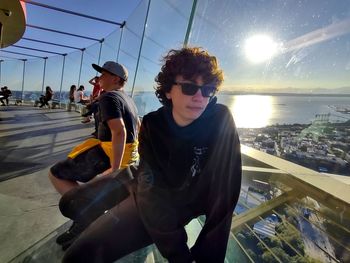 Low angle view of young woman wearing sunglasses against sky