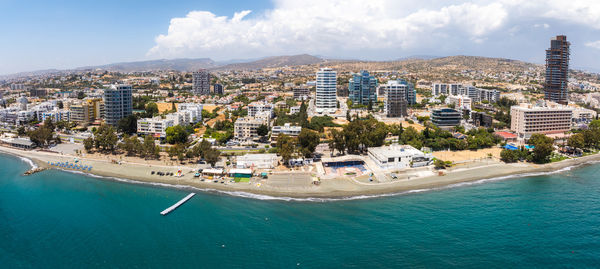 High angle view of townscape by sea against sky