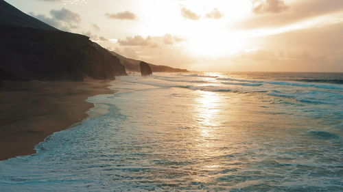 Cofete sand beach at sunset on paradise island fuerteventura, canary, spain. golden ocean water.