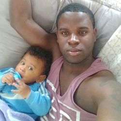 High angle portrait of father and son baby on bed at home