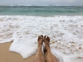 Low section of woman relaxing on beach