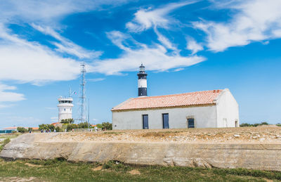 Lighthouse amidst buildings against sky