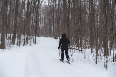 Rear view of man skiing on snow covered landscape