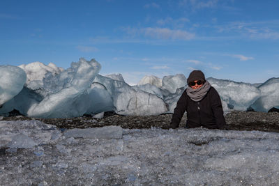 Portrait of mature woman at glacier against blue sky