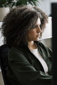 Focused businesswoman with curly hair working at office