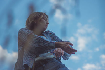 Low angle view of woman dancing against sky