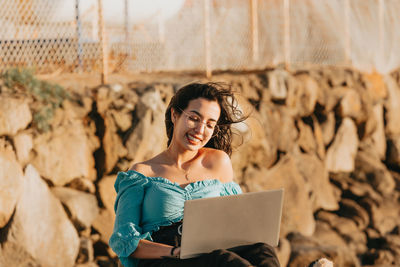 Portrait of smiling young woman sitting outdoors