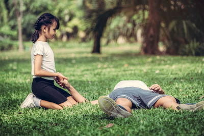 Full length of woman lying on grass in park