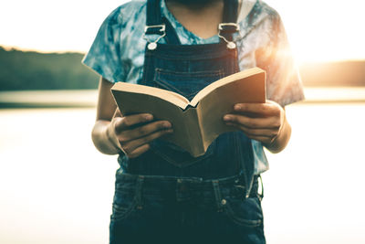 Midsection of woman reading book