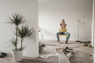 Mature woman moving house, sitting on chair