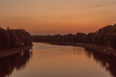 Scenic view of lake against orange sky