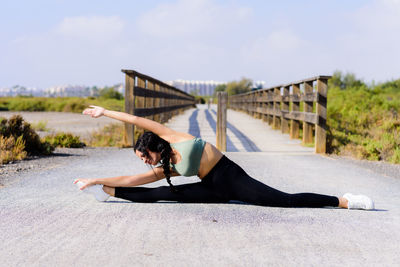 Woman lying down on floor against sky