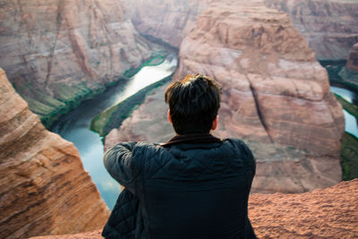 Rear view of woman standing on rock