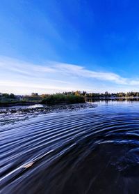 Scenic view of river against blue sky