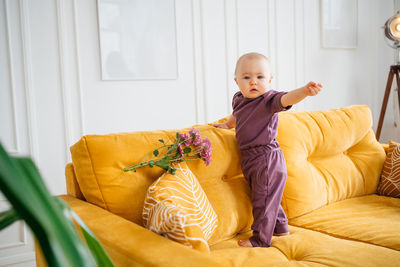 Side view of young woman sitting on bed at home