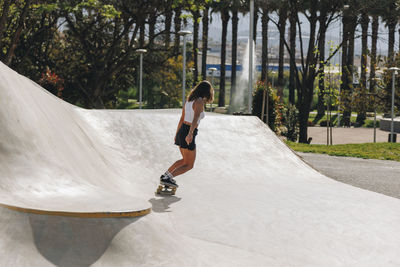 Woman skateboarding on sports ramp