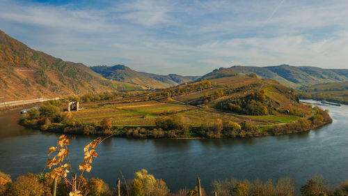 Scenic view of river moselle amidst mountains against sky