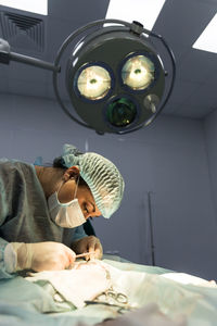 Side view of surgeon working in operating room