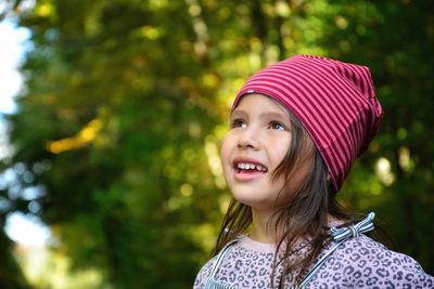 Portrait of a smiling girl against trees