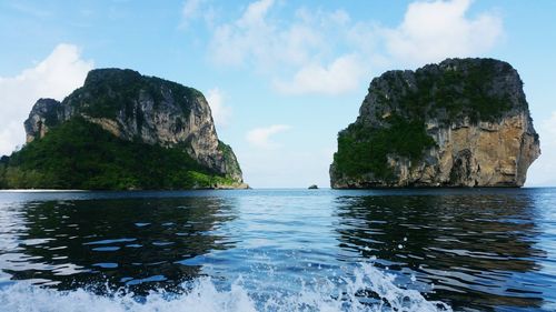 Scenic view of sea by cliff against sky