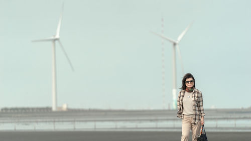 Young woman standing against clear sky