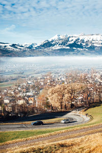 Aerial view of city by mountain against sky