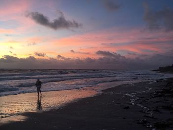 Man standing against sea during sunset