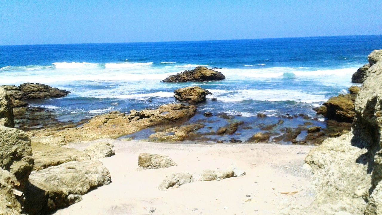 sea, horizon over water, water, beach, scenics, clear sky, tranquil scene, beauty in nature, shore, tranquility, rock - object, nature, wave, surf, rock formation, blue, idyllic, rock, coastline, copy space