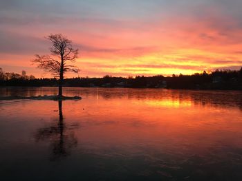 Scenic view of lake against orange sky