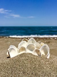 Lounge chairs on sand at beach against sky