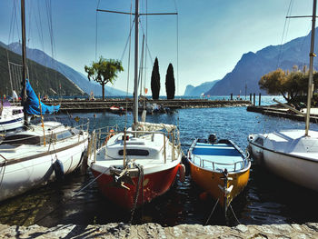 Boats moored at harbor against sky