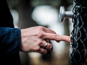 Close-up of man pushing button on door