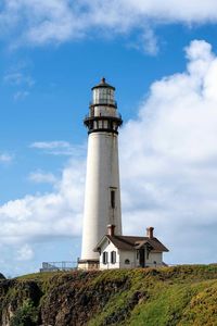 Lighthouse by sea against sky