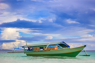 Fishing boats moored at sea against sky