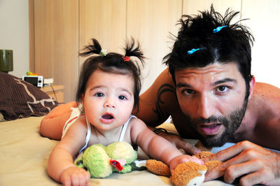 Portrait of father and daughter wearing hair clips at home